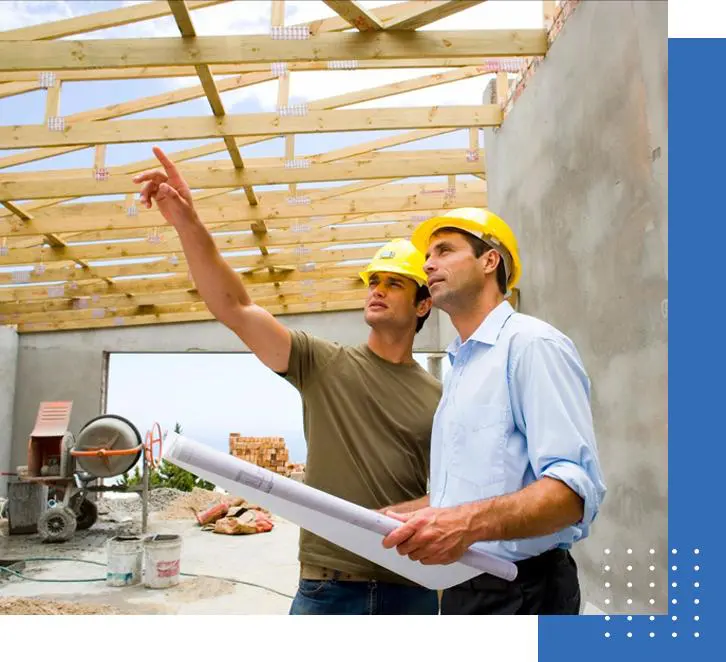 Two men in hard hats looking at a building