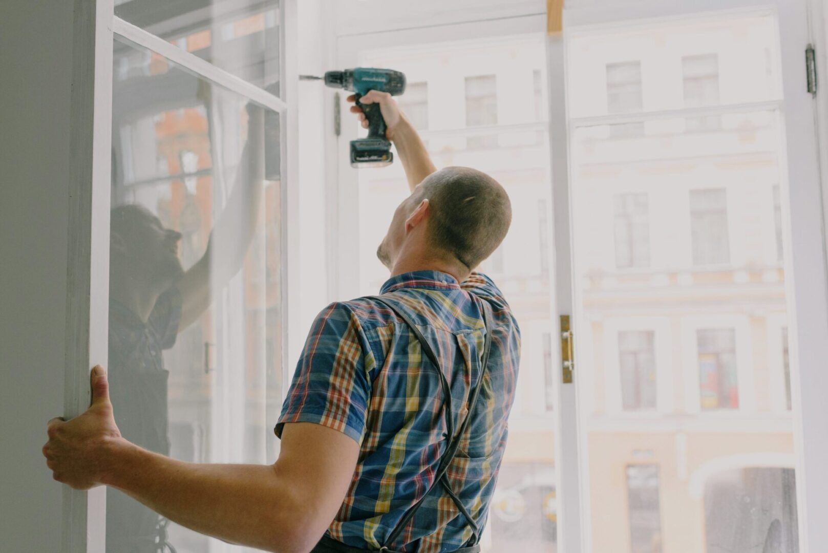 A man holding a drill in his hand.